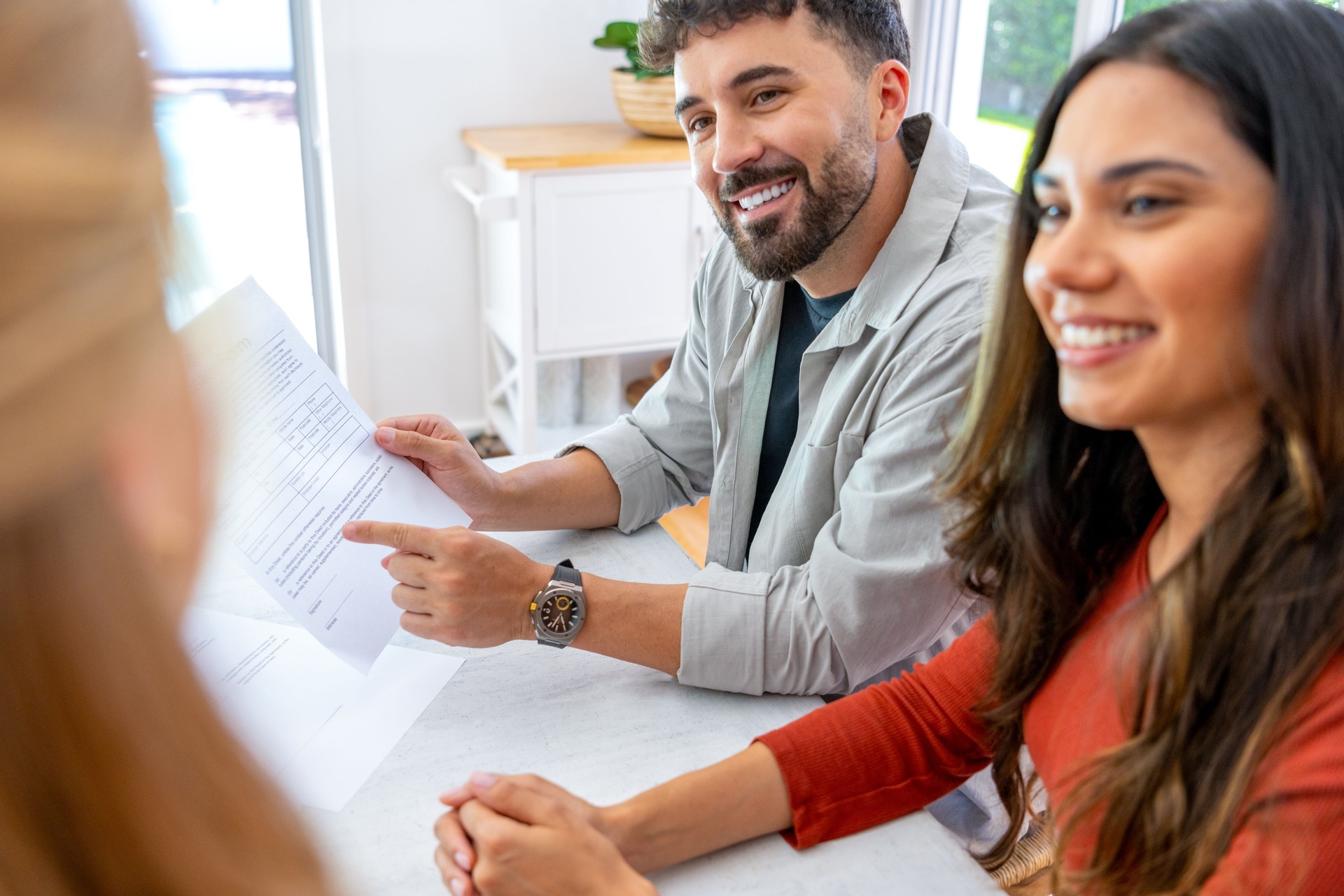 Real Estate or Insurance agent with couple looking through mortgage documents.