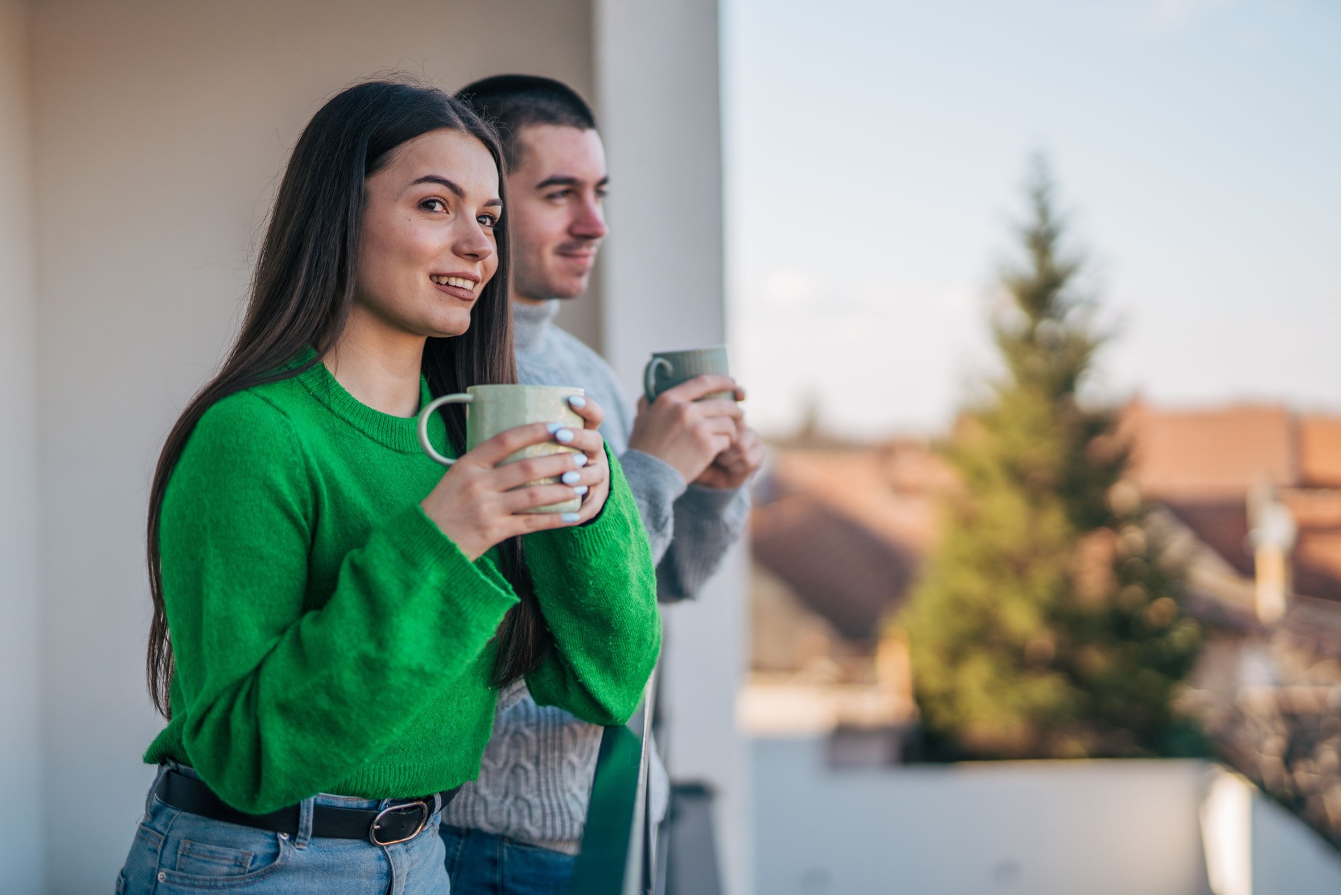 Couple standing on their new apartment terrace and enjoying the beautiful view.